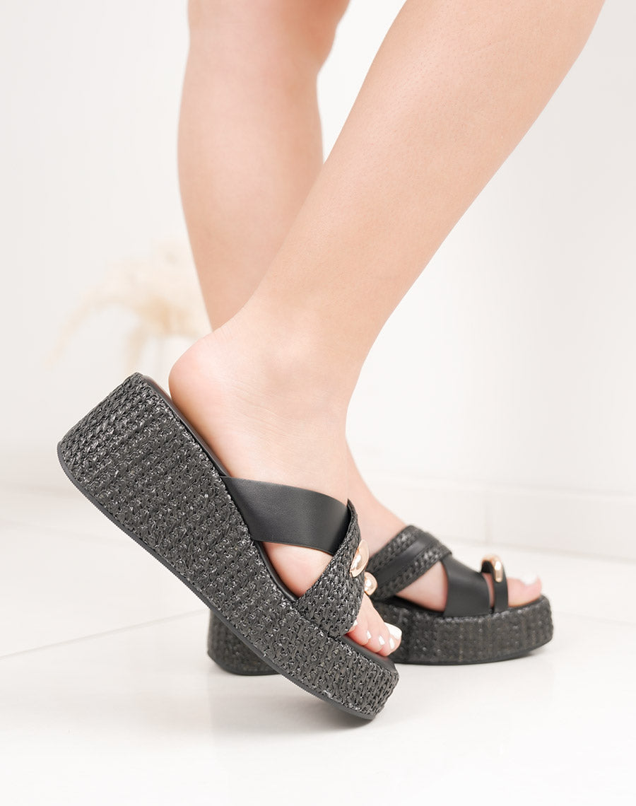 Mules noires compensées à plateforme avec lanière tissée et bijou doré