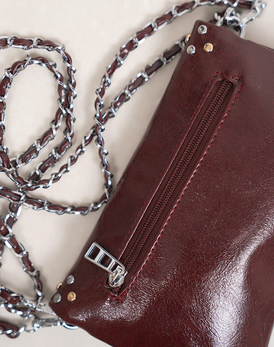 Sac pochette femme bordeaux brillant avec clous décoratifs et fermeture zippée argentée