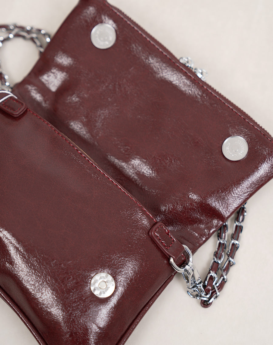 Sac pochette femme bordeaux brillant avec clous décoratifs et fermeture zippée argentée