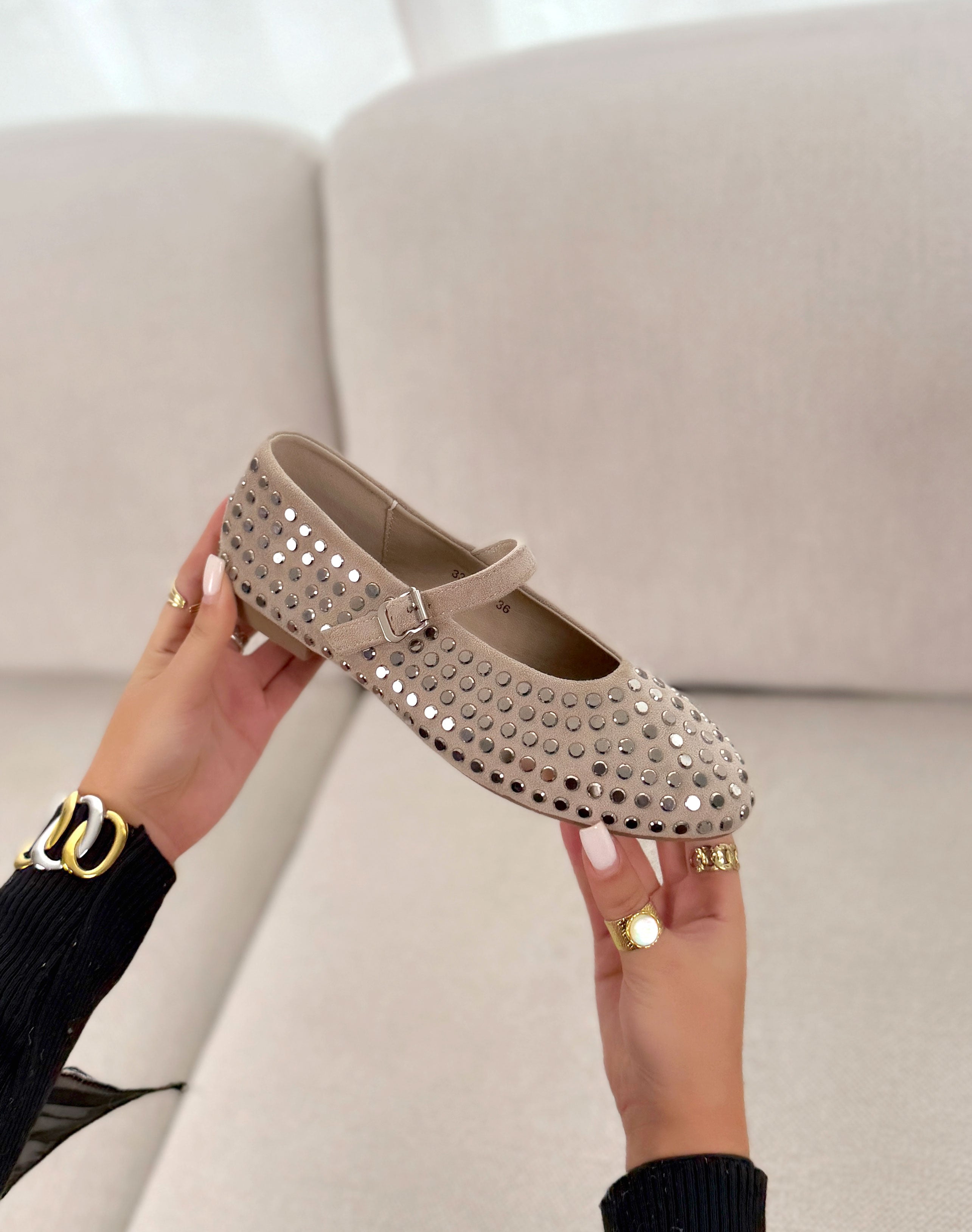 Ballerines beige plates avec détails brillants argentés et lanière ajustable.