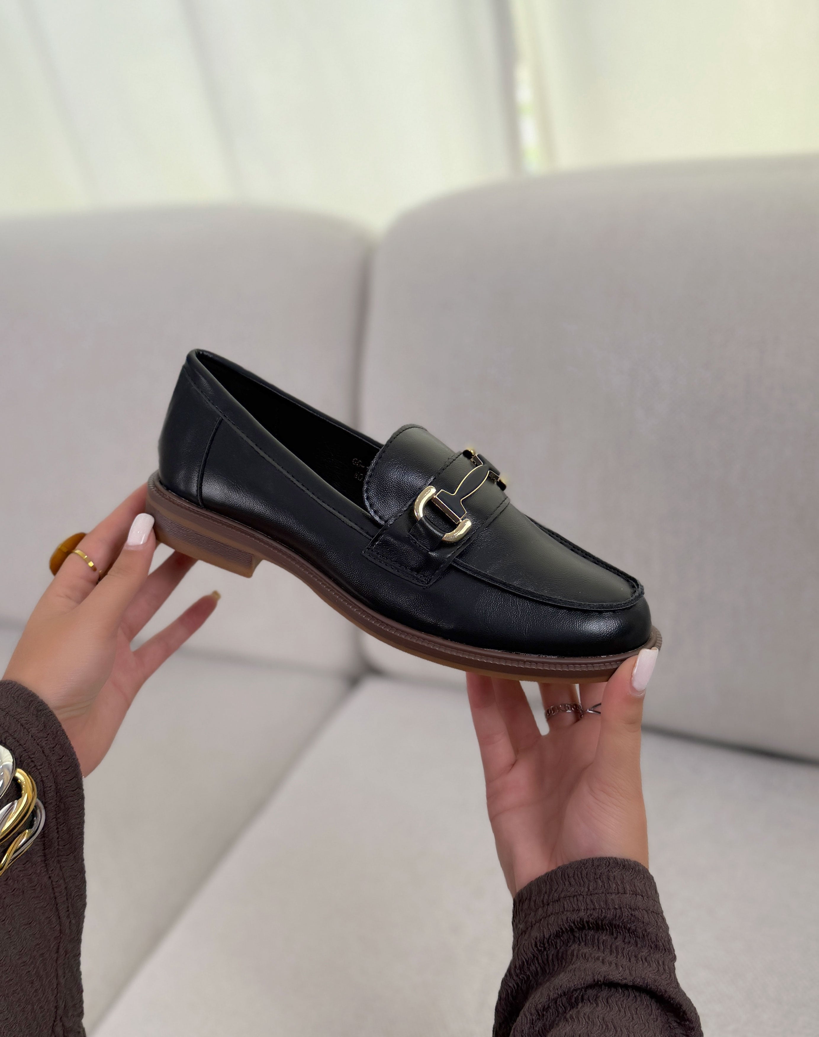 Mocassin femme noir élégant à bijou doré et semelle plate marron