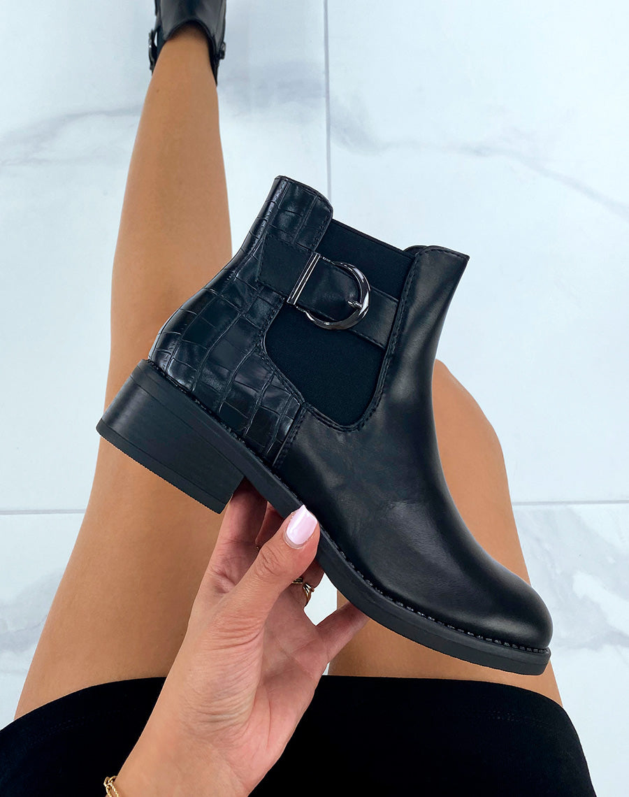 Bottines basses noires effet croco ornées d’une bride