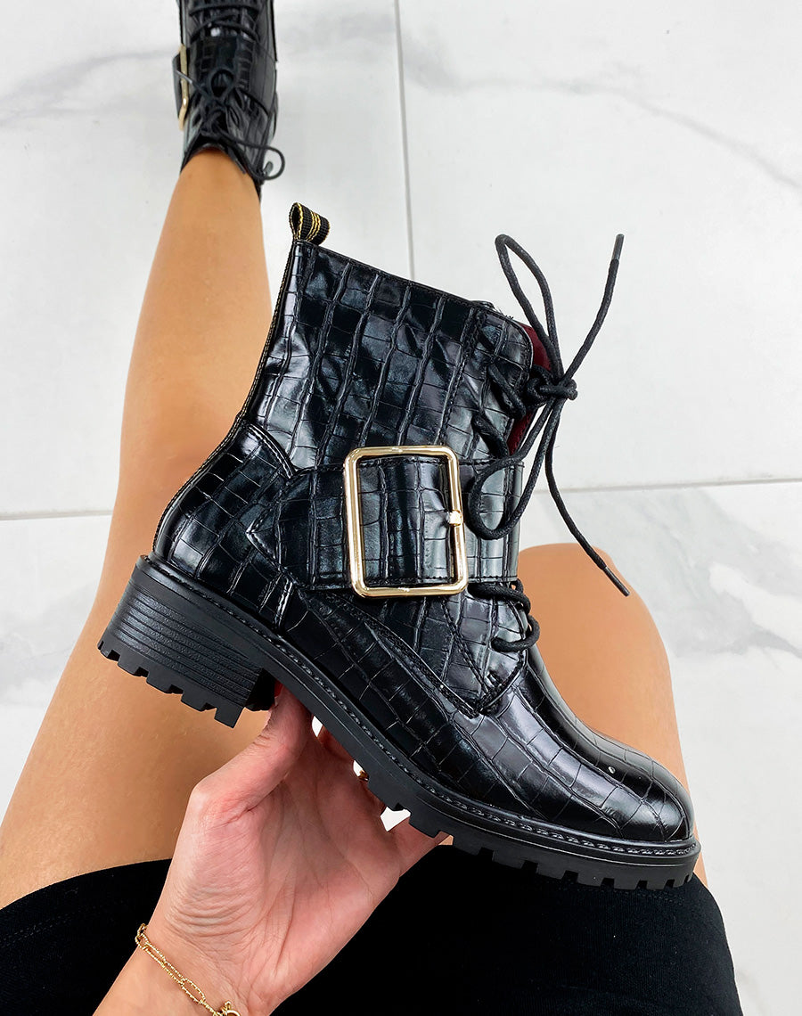 Bottines noires effet croco ornées d’une grosse boucle dorée