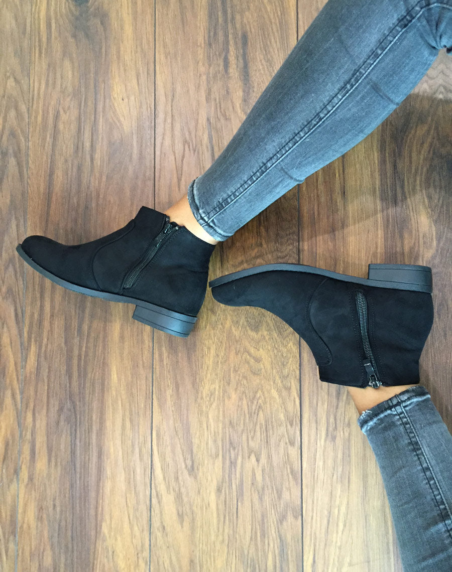 Bottines plates noires avec pompons à franges