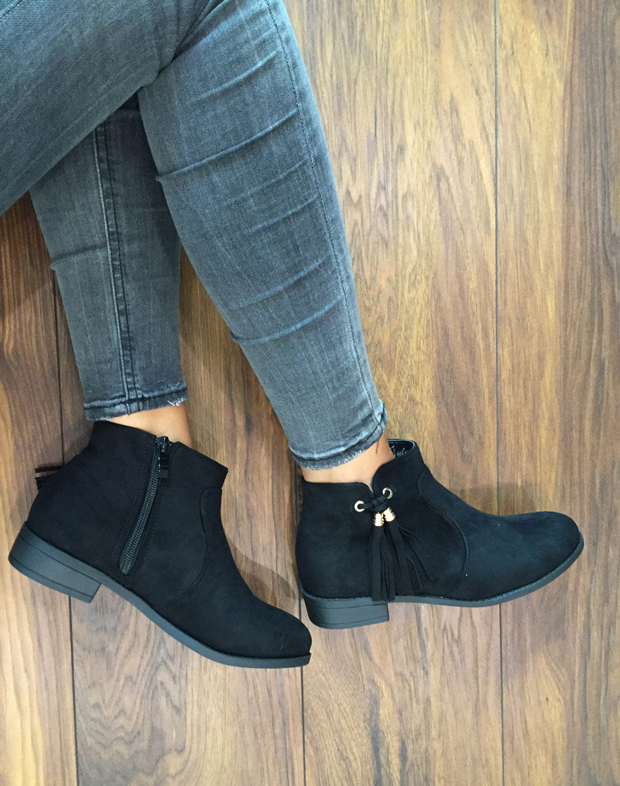 Bottines plates noires avec pompons à franges