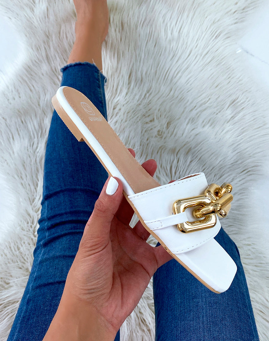 Mules blanches plates à grosse chaîne dorée et bout carré