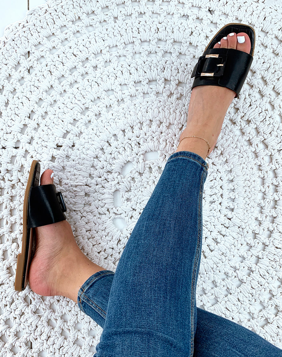 Mules en similicuir noires à grosse boucle