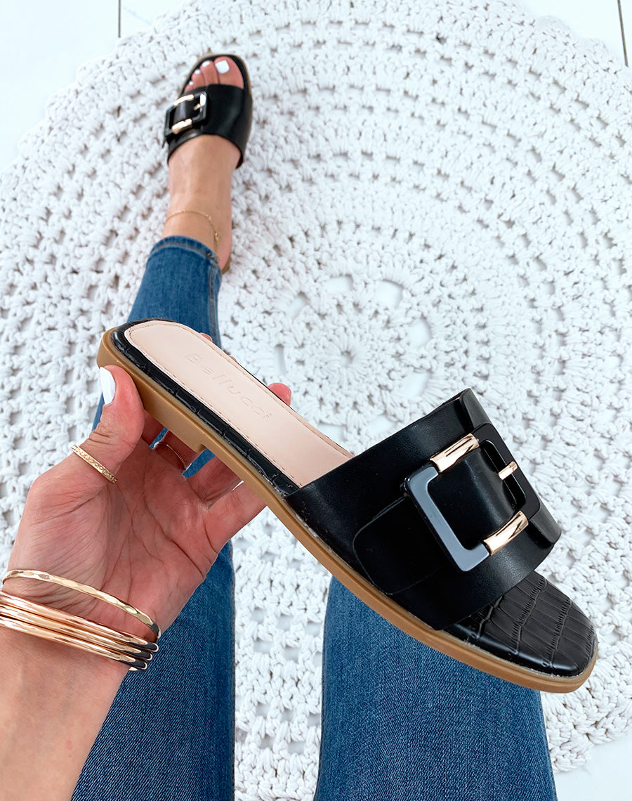Mules en similicuir noires à grosse boucle