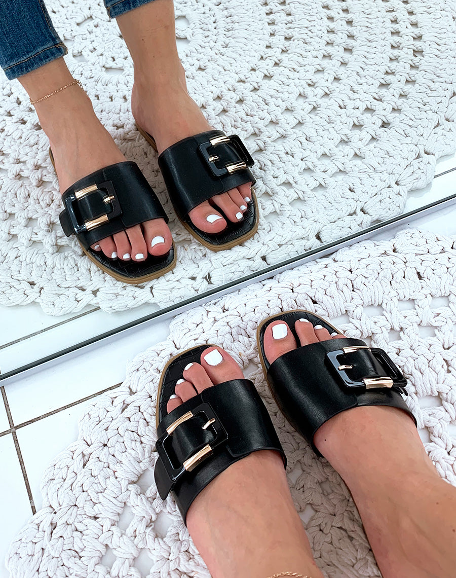 Mules en similicuir noires à grosse boucle