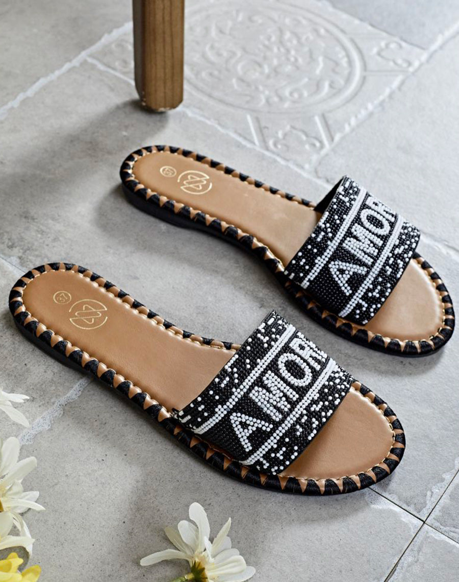 Mules noires à bride avant à inscription perlée