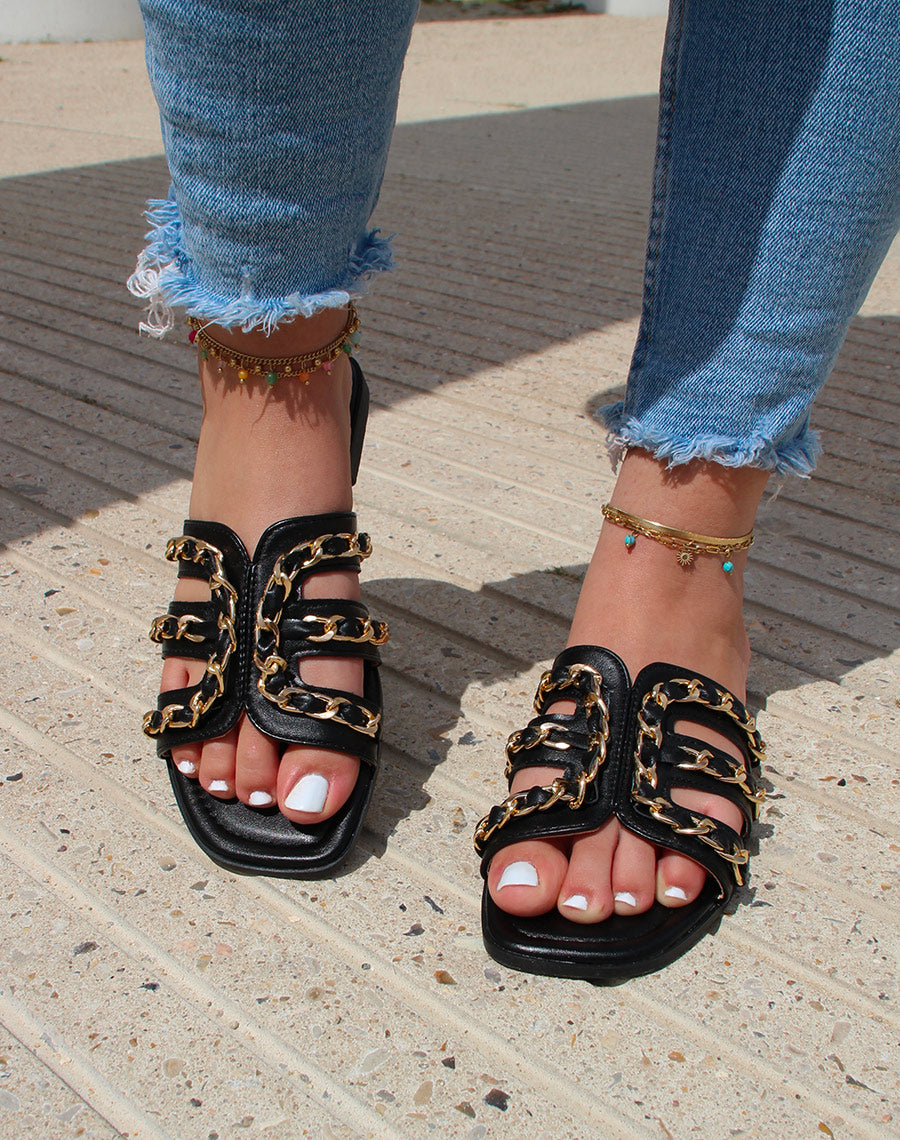 Mules noires à brides ouvertes croisées à chaîne dorée