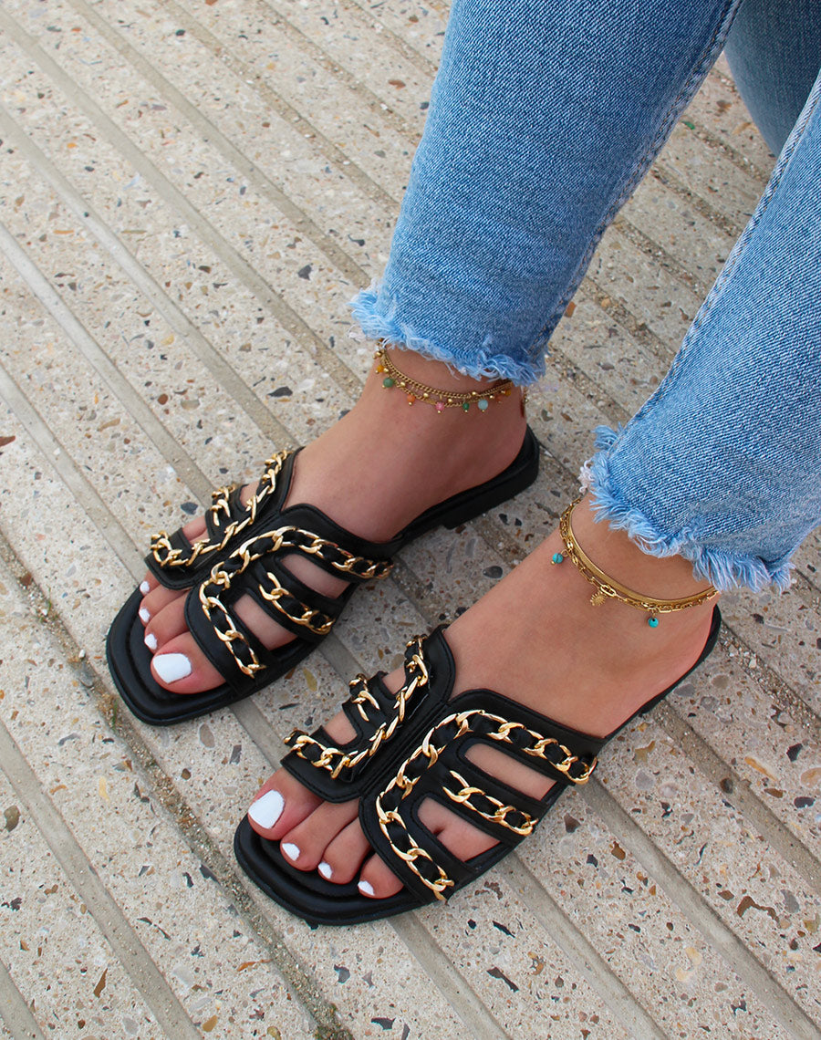 Mules noires à brides ouvertes croisées à chaîne dorée