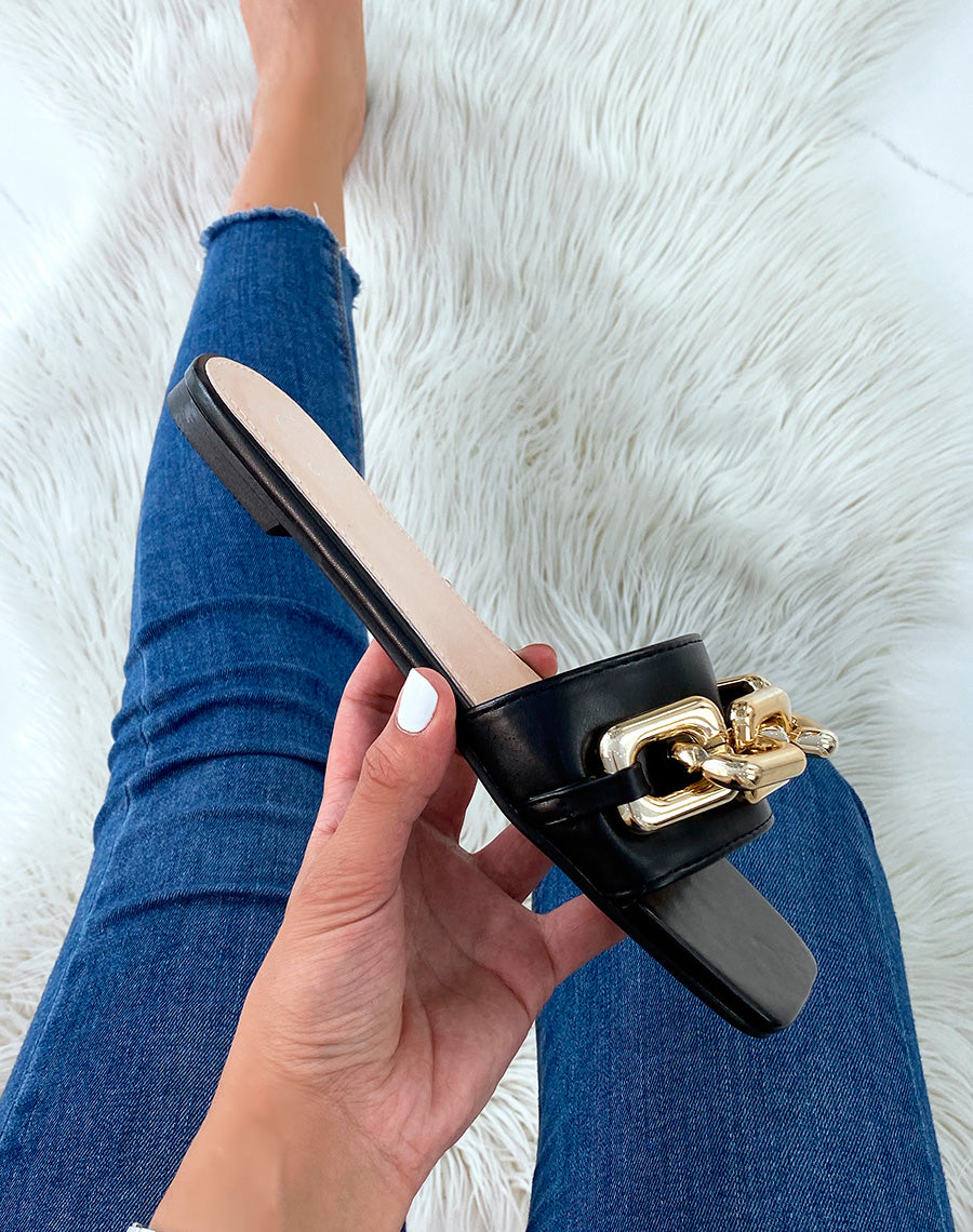 Mules noires plates à grosse chaîne dorée et bout carré