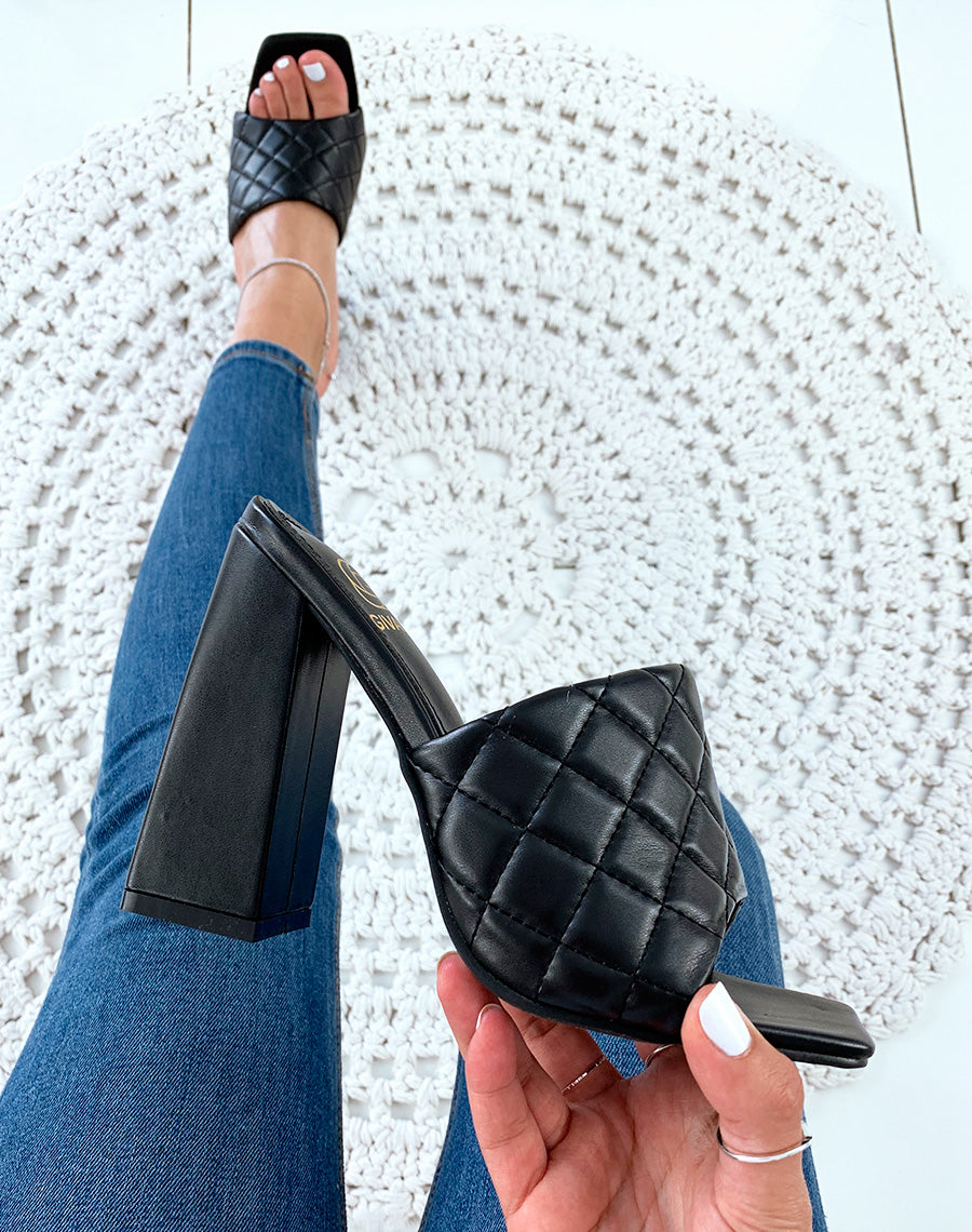 Mules noires à talons carrés et à larges brides matelassées
