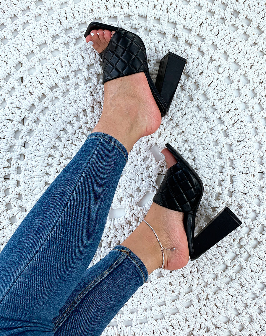 Mules noires à talons carrés et à larges brides matelassées