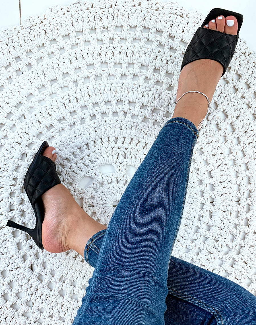 Mules noires à talons et à larges brides matelassées