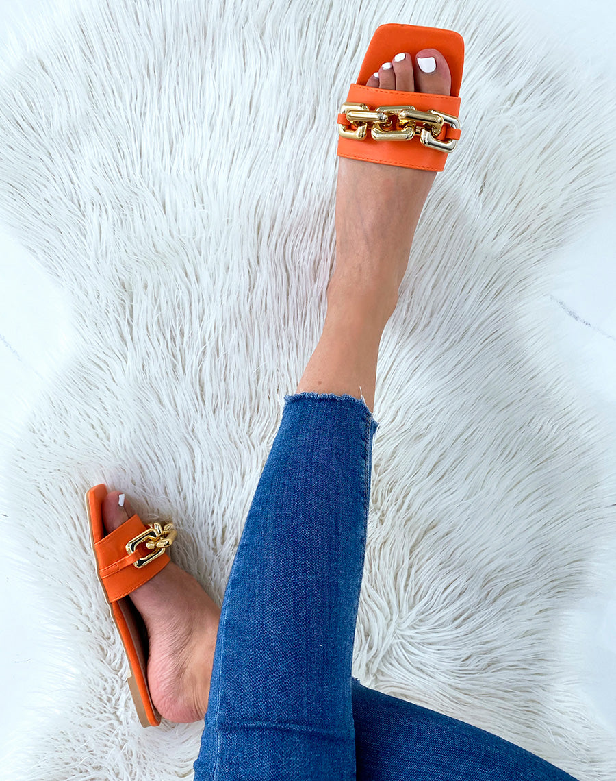 Mules oranges plates à grosse chaîne dorée et bout carré