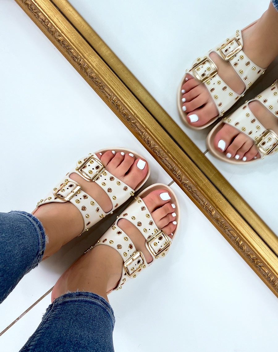 Mules plates beiges à lanières ajustables et clous dorés