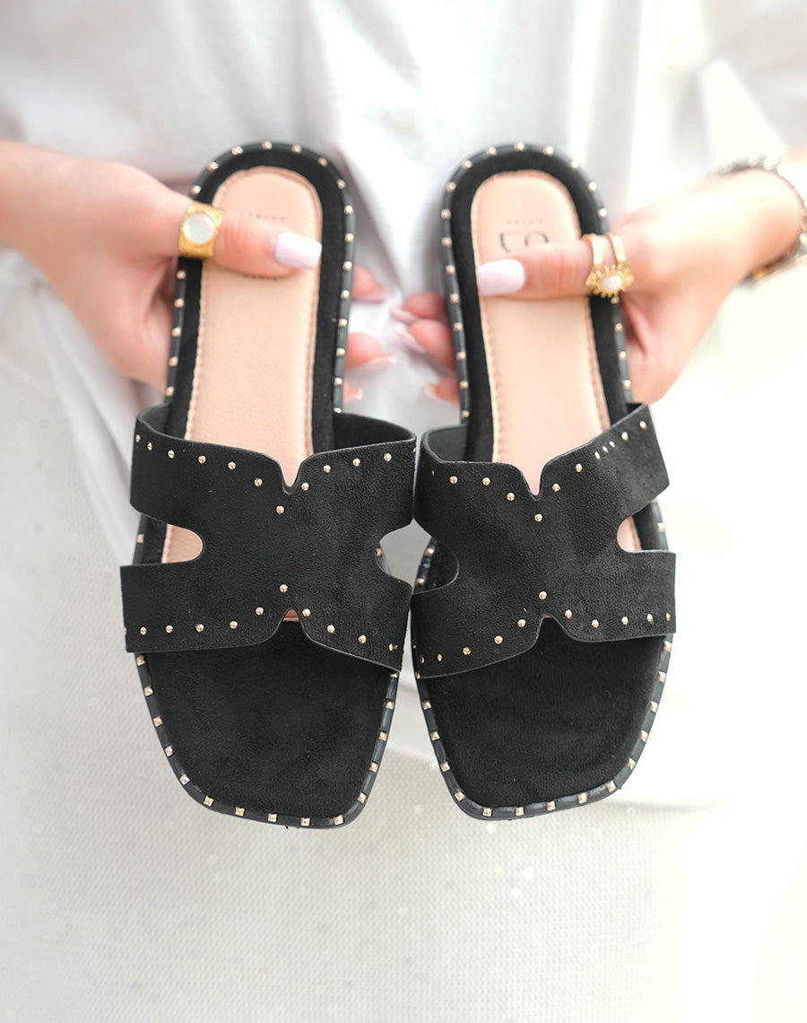 Mules plates en suédine noires à détail cloutées dorées