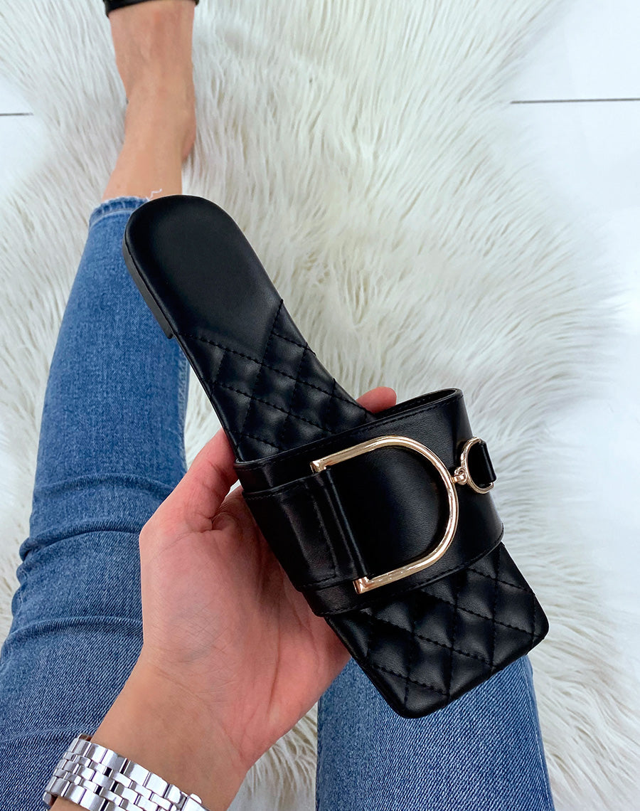 Mules plates noires à détail doré asymétrique