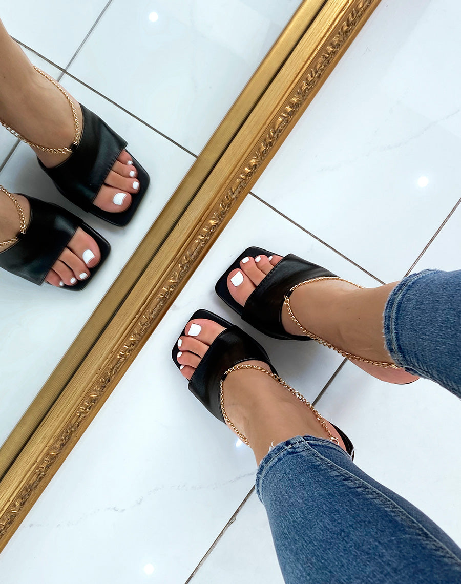 Mules à talon noir et à chaîne dorée