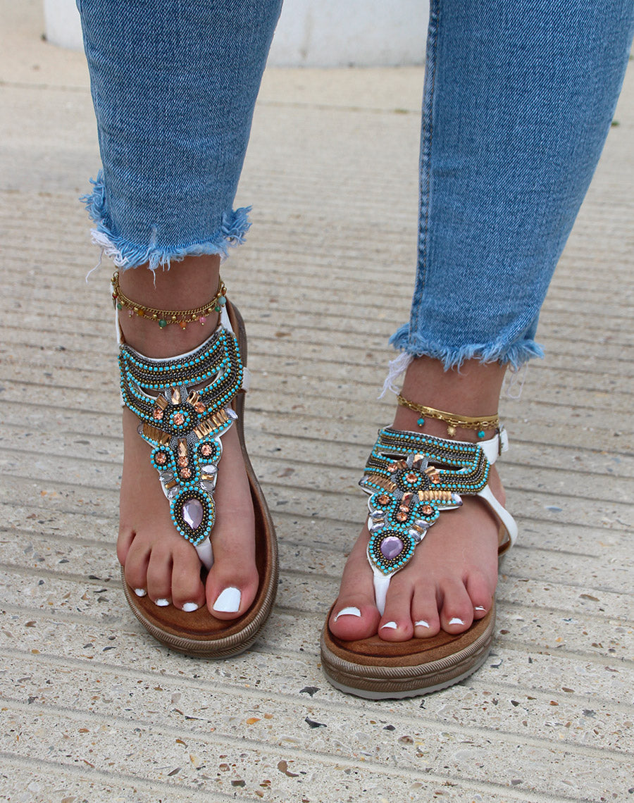 Nu-pieds blancs à entre-doigt orné de bijoux bleus roses et dorés