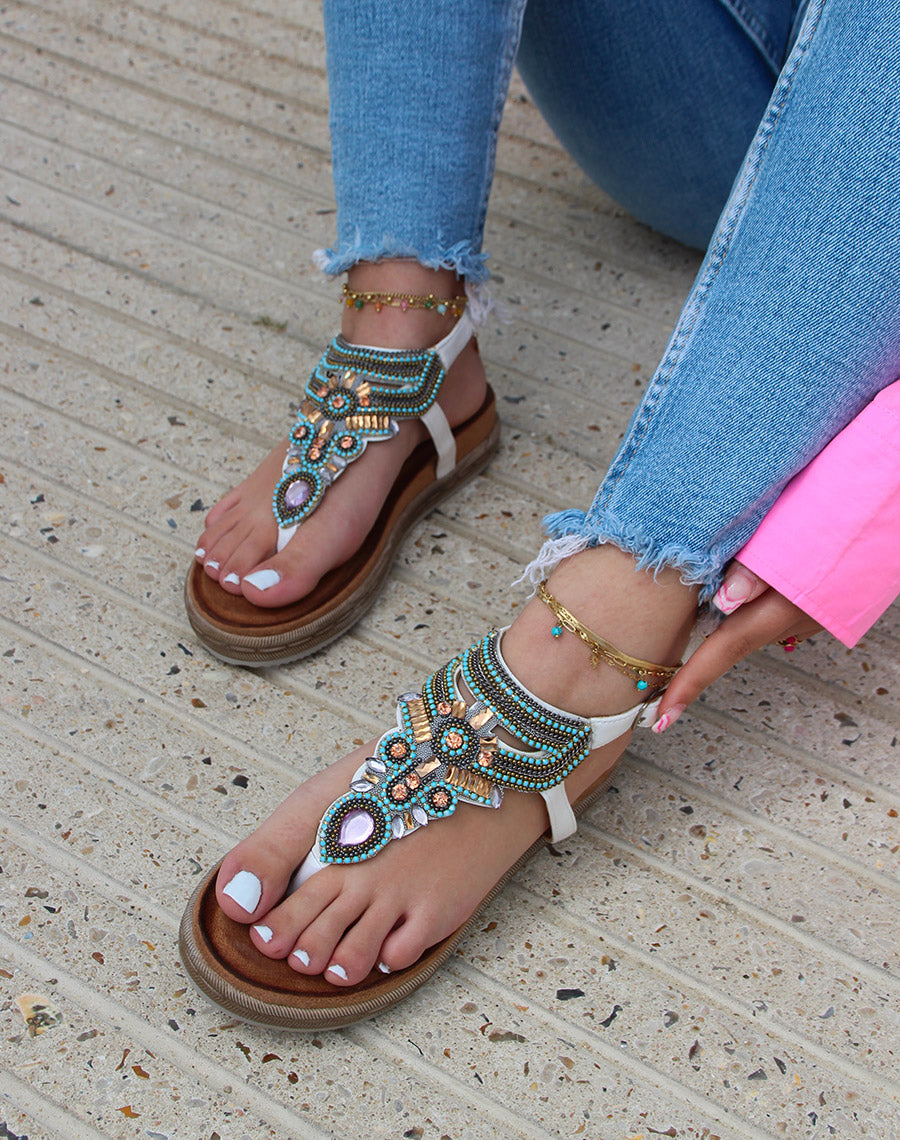 Nu-pieds blancs à entre-doigt orné de bijoux bleus roses et dorés