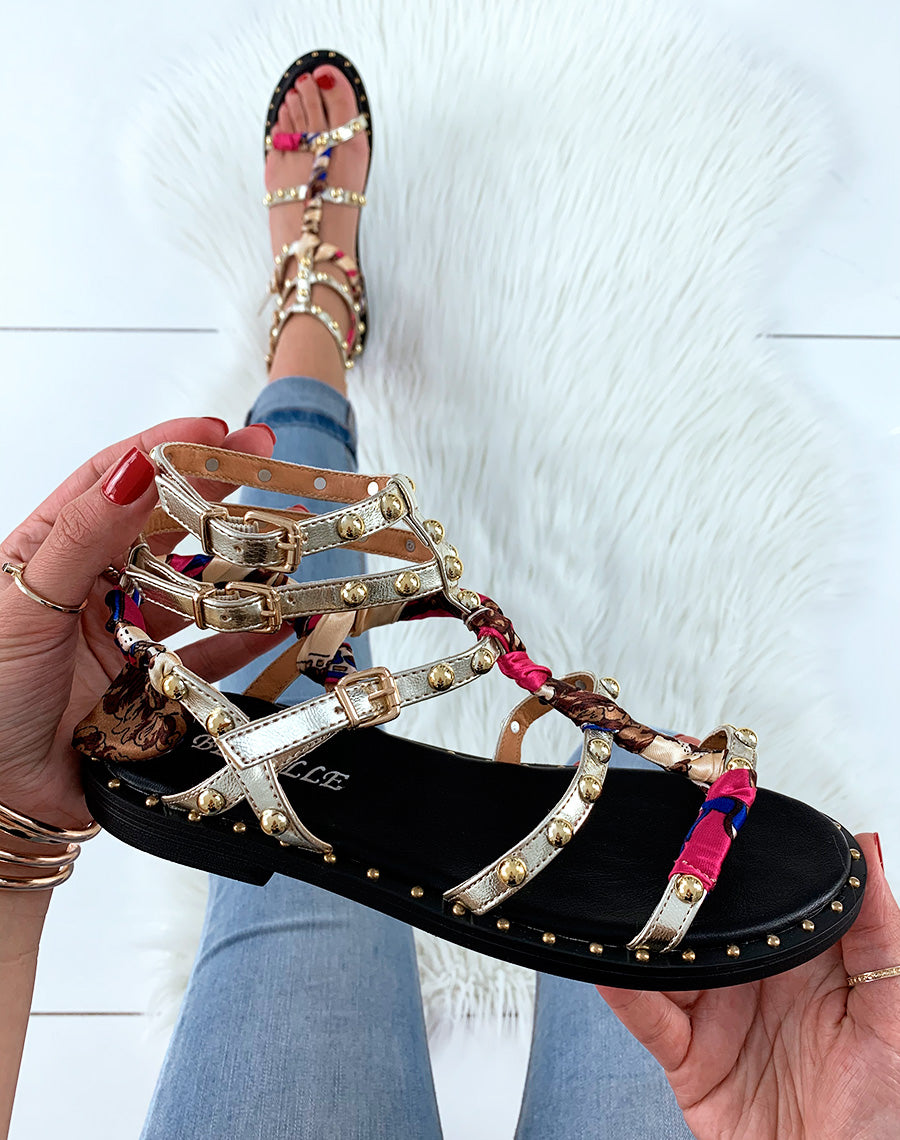 Nu-pieds dorés à lanières ornées de clous avec détails foulard