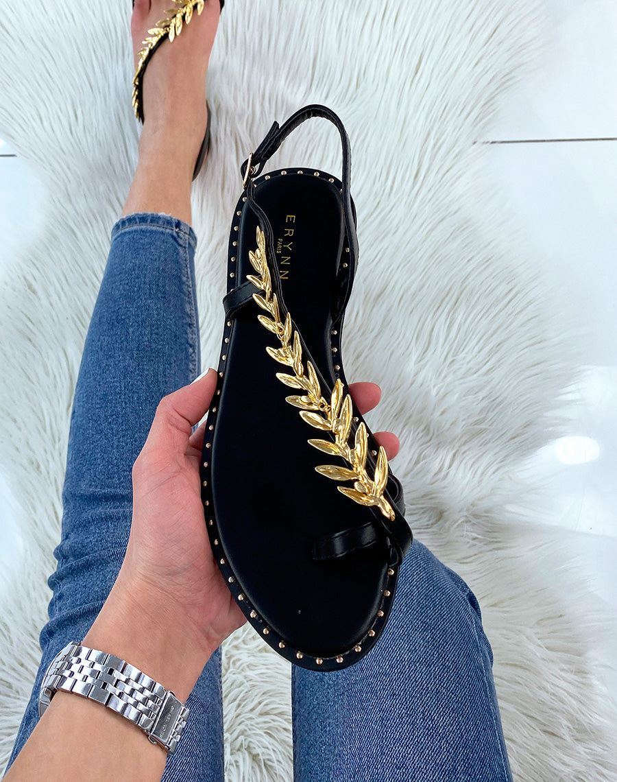 Nu-pieds noirs ornés d’un bijou doré en forme de laurier