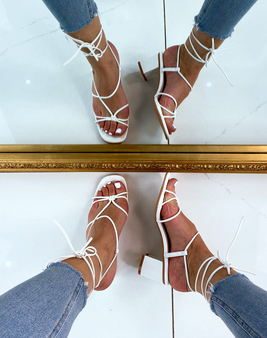 Sandales blanches à petit talon et multiples lanières