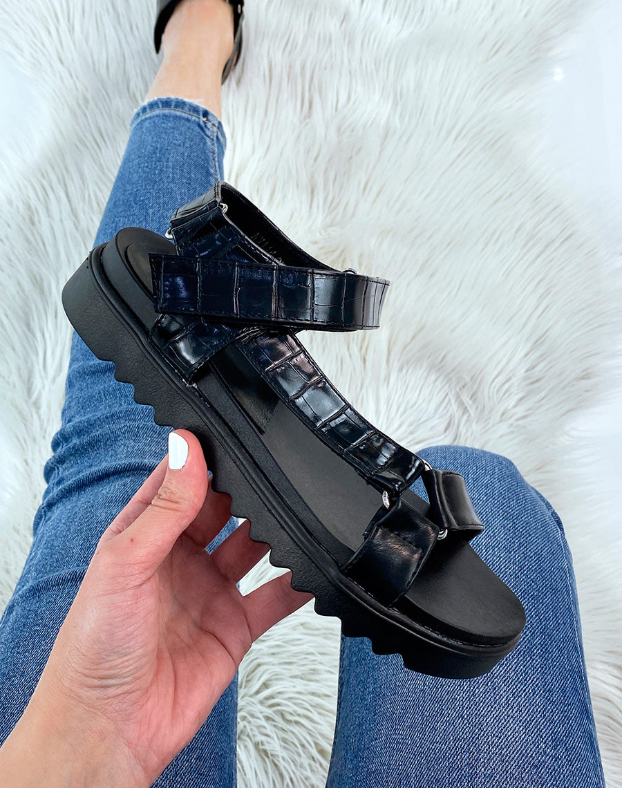 Sandales noires à semelle crantée et lanières asymétriques