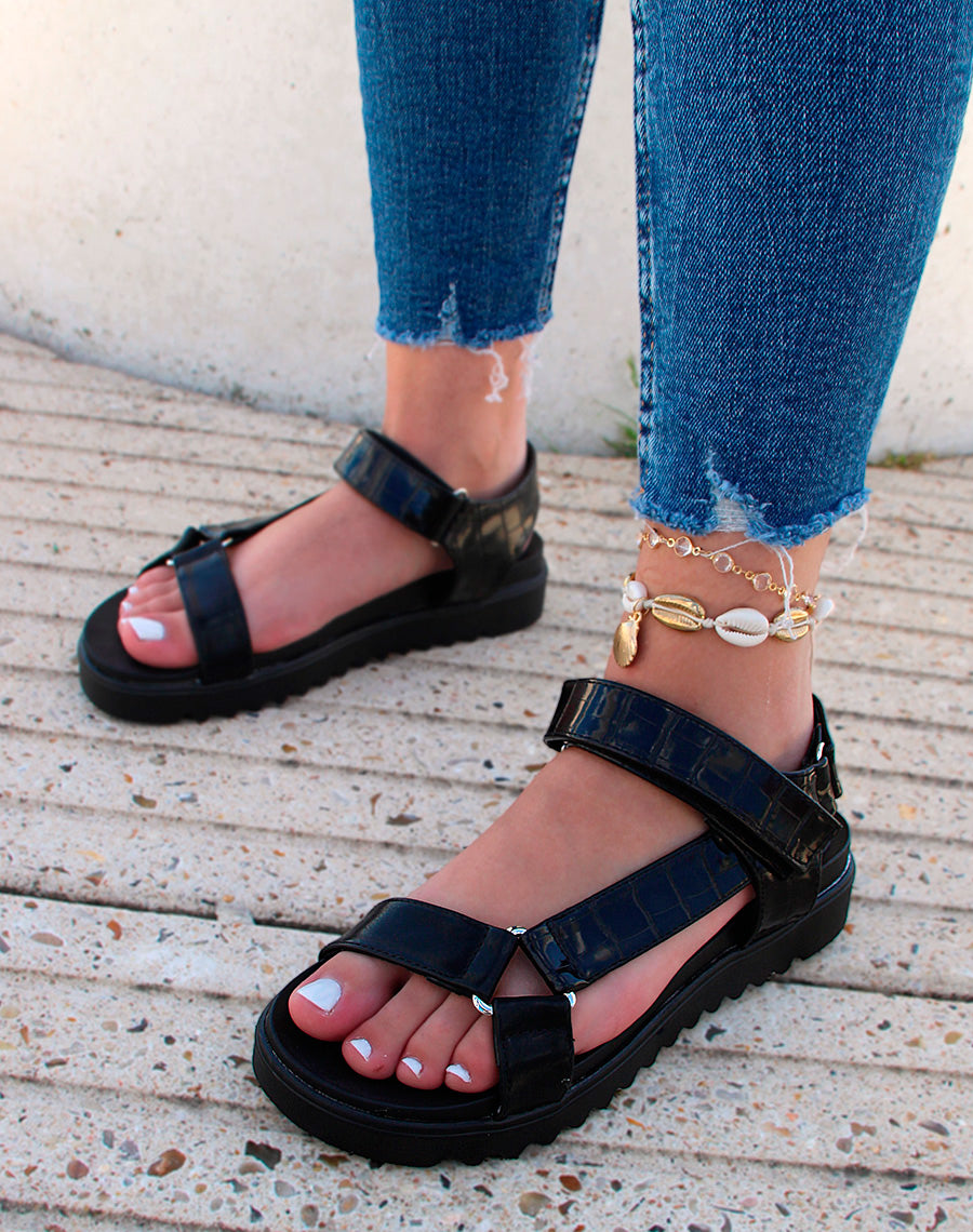 Sandales noires à semelle crantée et lanières asymétriques