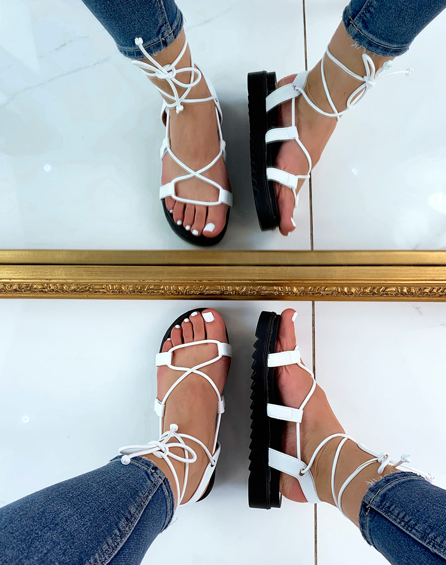 Sandales plates blanches à longues lanières et semelle crantée