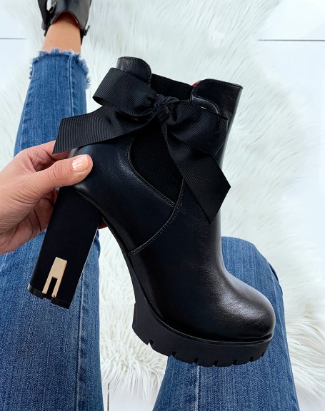 Black heeled ankle boots decorated with a bow