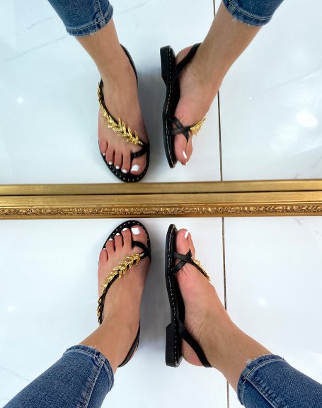 Black sandals adorned with a golden jewel in the shape of a laurel