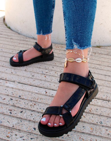 Black sandals with notched sole and asymmetric straps