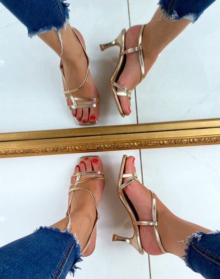 Gold sandals with a small thin heel and crossed straps