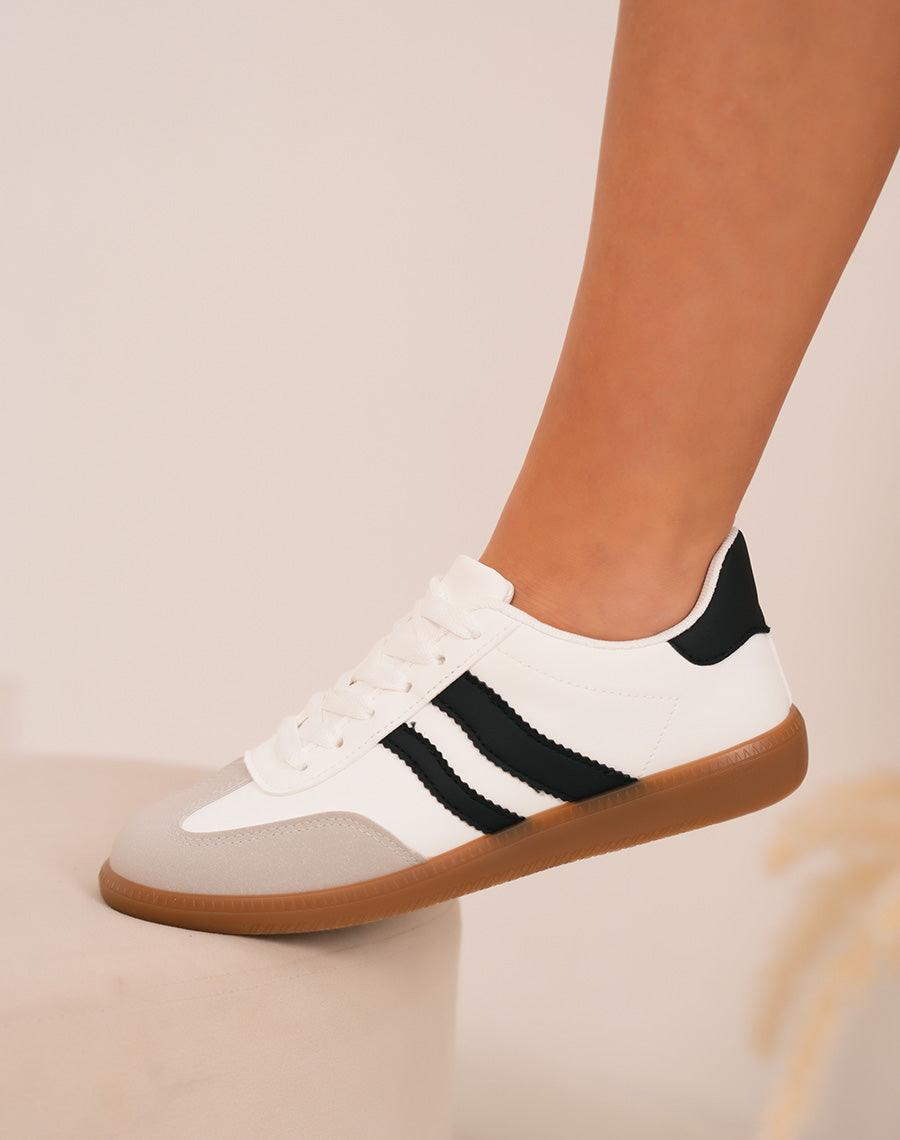 Trendy white women's sneakers with black scratches and brown sole