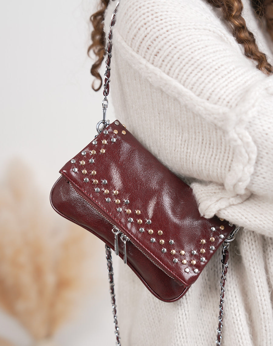 Sac pochette femme bordeaux brillant avec clous décoratifs et fermeture zippée argentée