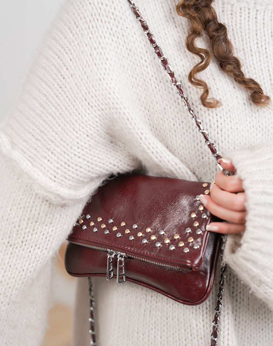 Sac pochette femme bordeaux brillant avec clous décoratifs et fermeture zippée argentée