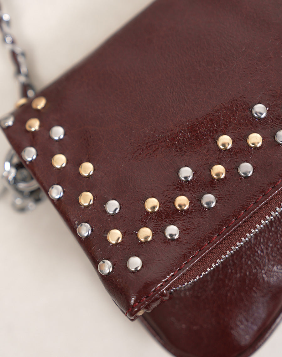 Sac pochette femme bordeaux brillant avec clous décoratifs et fermeture zippée argentée