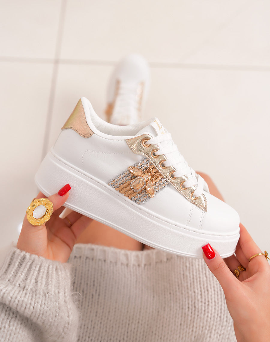 Elegant white women's sneakers with bee jewelry and grained golden details