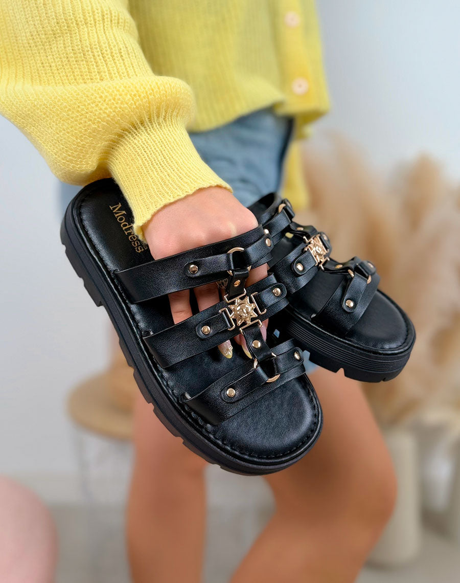Mules femme noires tendance à triple lanière avec bijoux dorés et semelle crantée