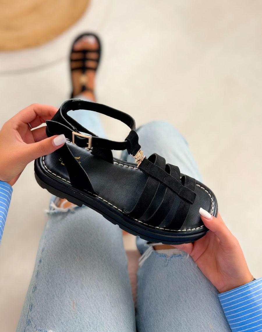 Sandales femme noires tendance en suédine avec semelle crantée et bijou soleil doré