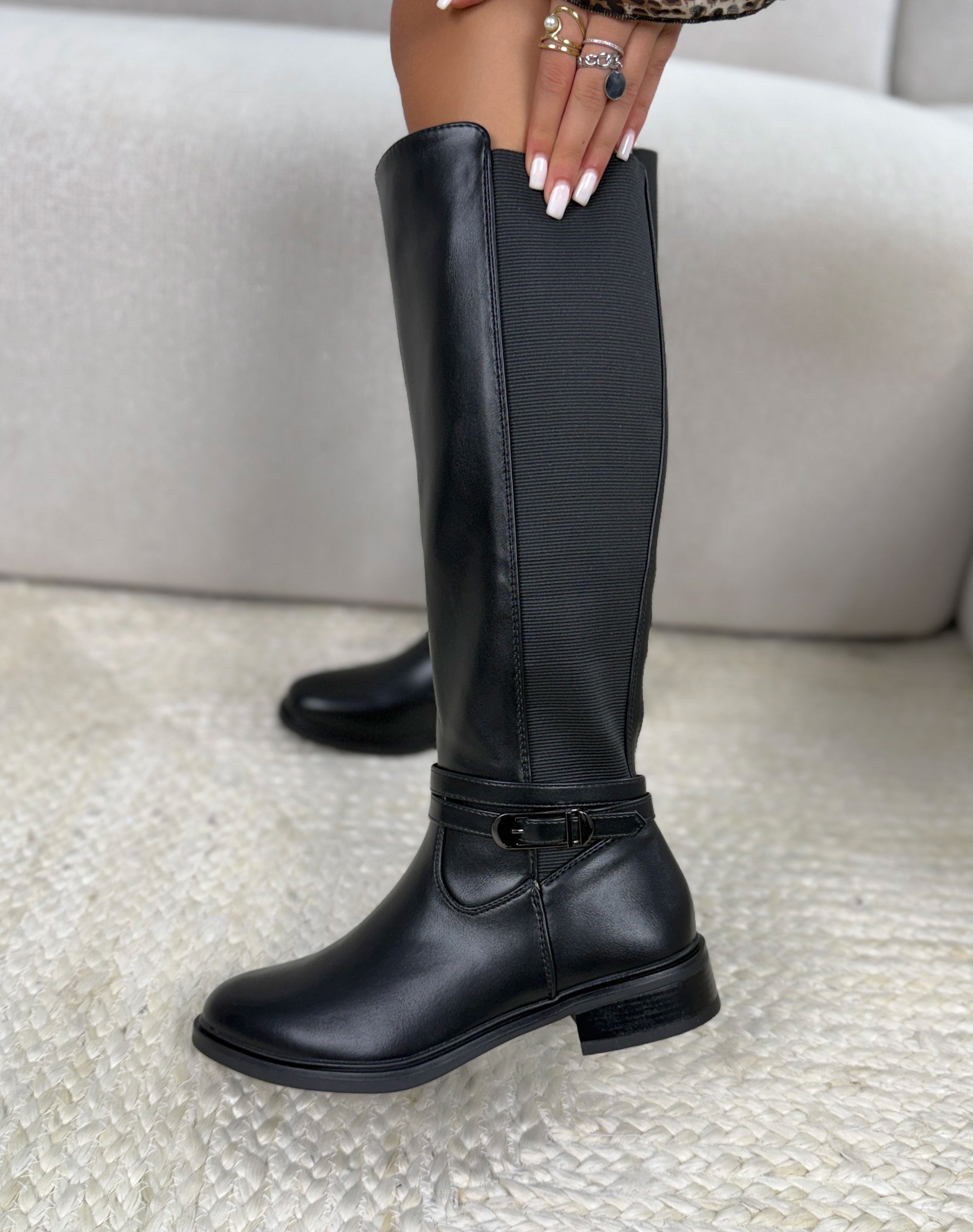 Bottes noires à tige élastique avec sangle décorative et petit talon.