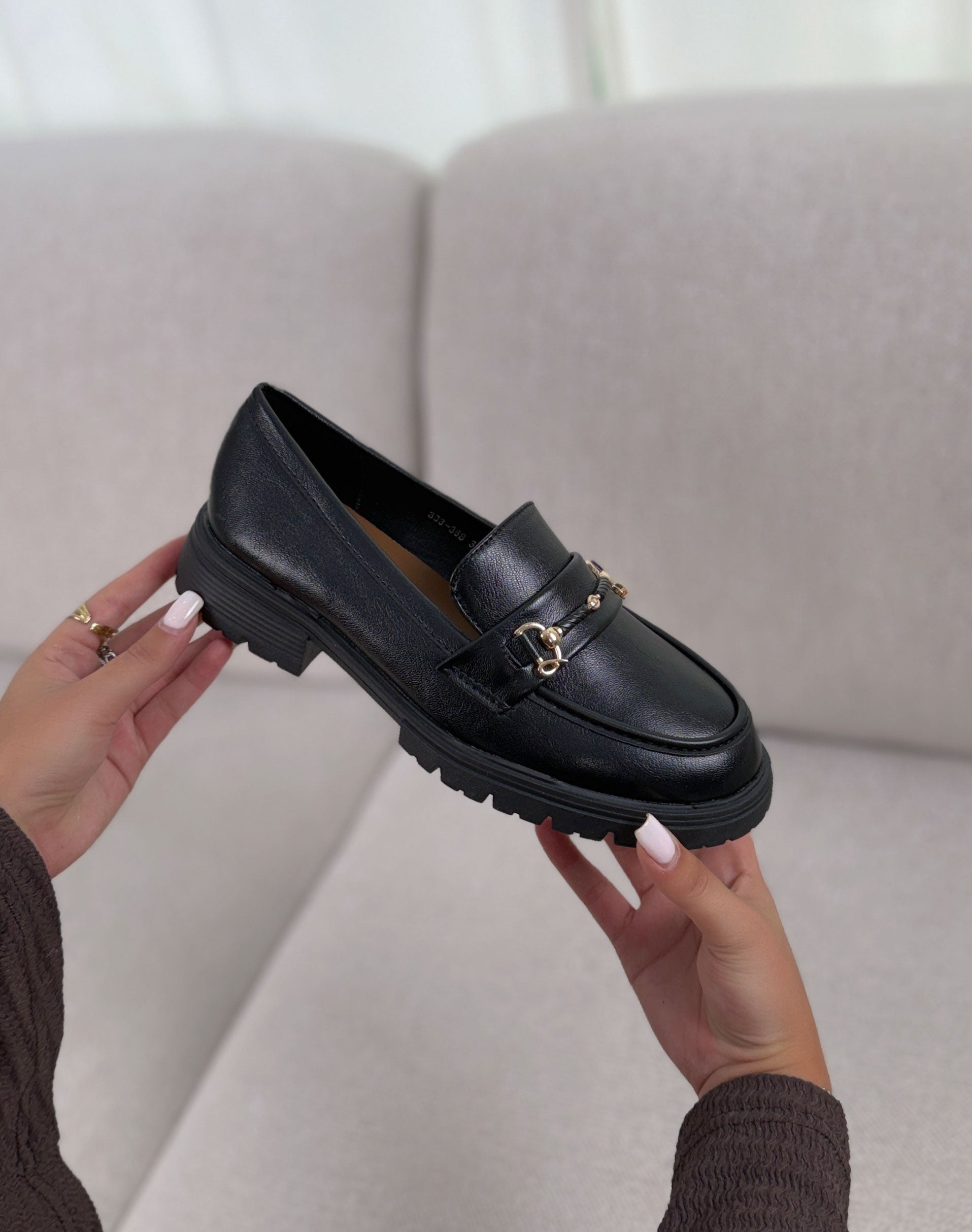 Mocassins noirs à bijou doré à semelle et talon crantée.