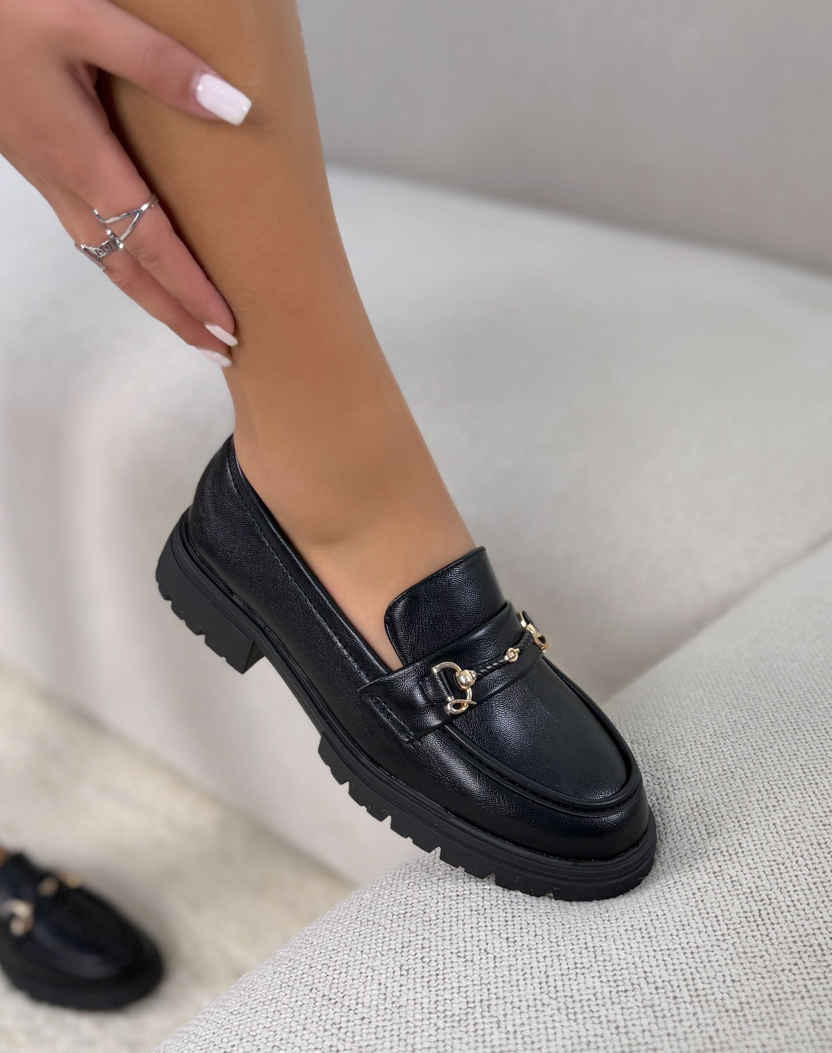 Mocassins noirs à bijou doré à semelle et talon crantée.