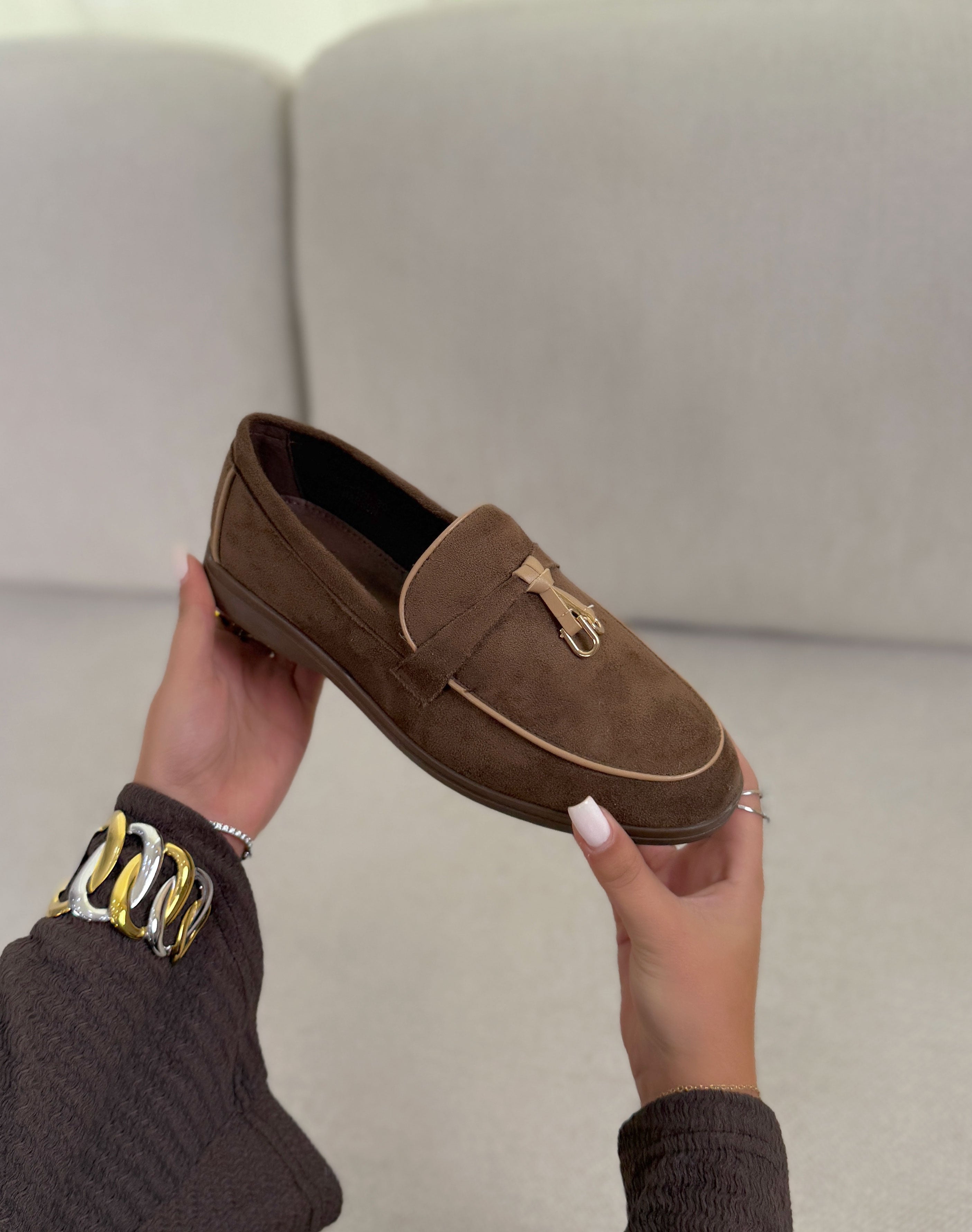 Mocassins marron en suédine avec détail beige foncé et doré avec semelle plate.