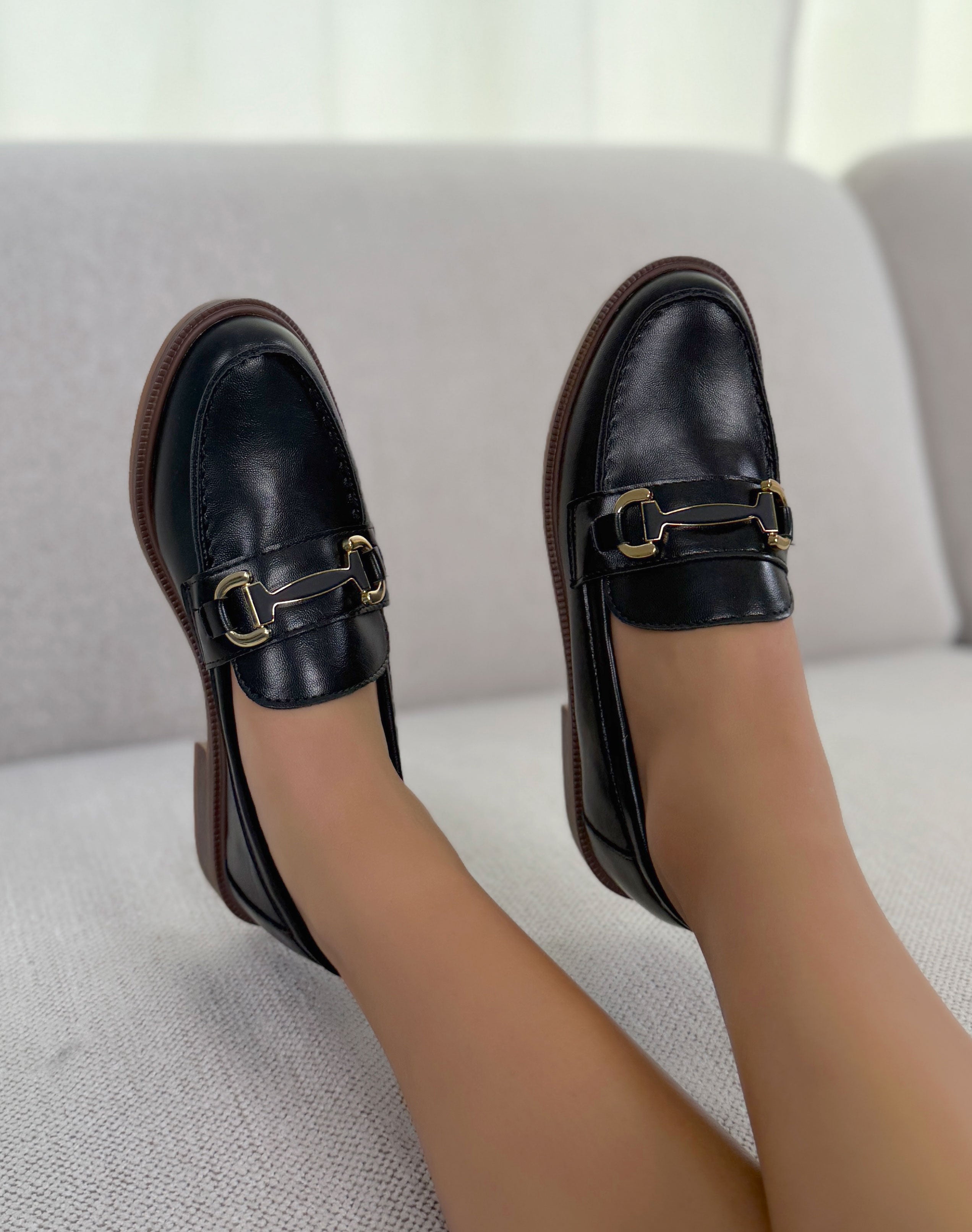 Mocassin femme noir élégant à bijou doré et semelle plate marron