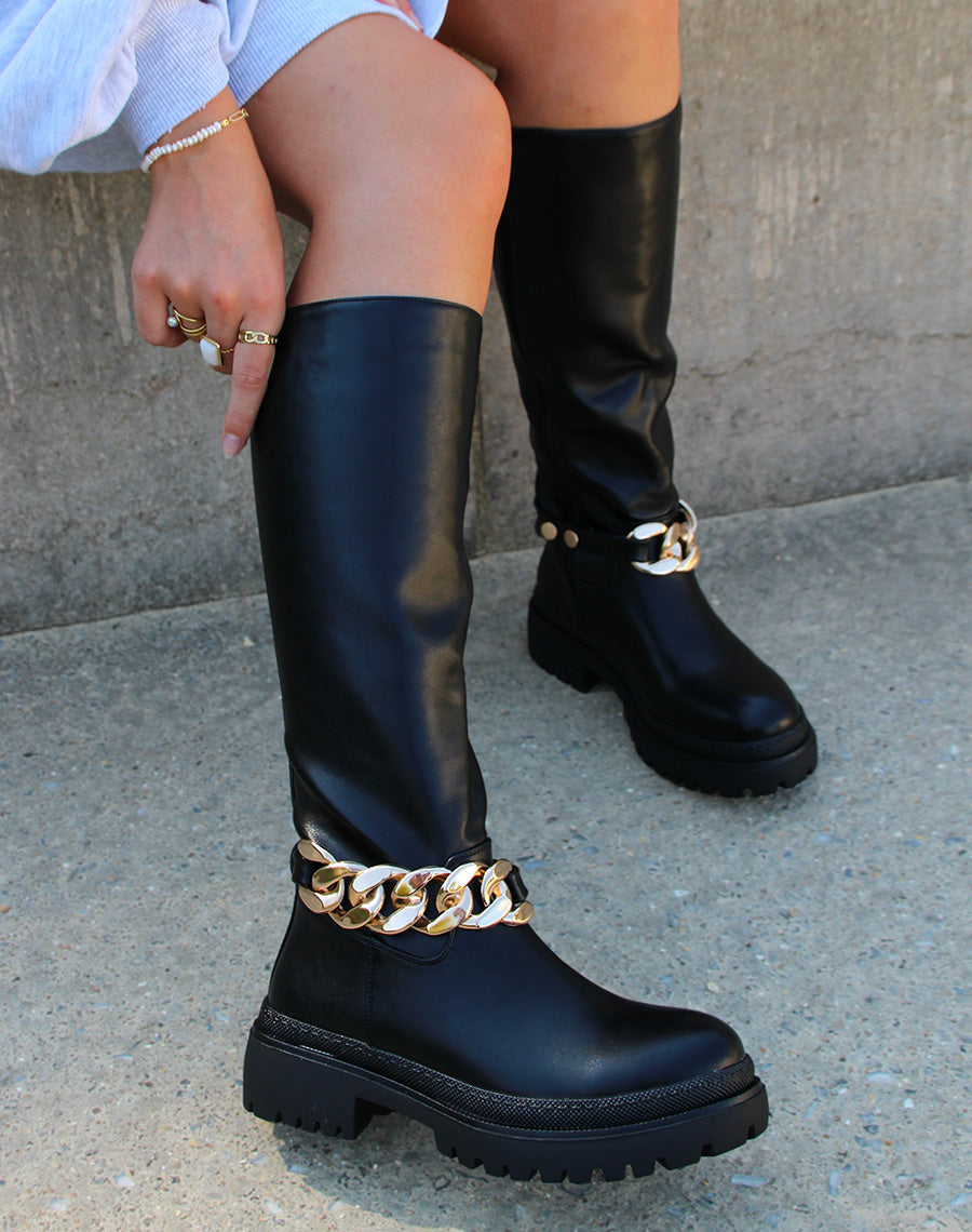 Bottes hautes noires ornées d’une chaîne dorée